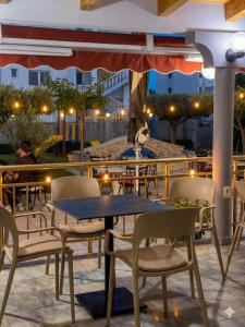 a table and chairs on a patio at night at Hotel Restaurant Globi in Velipojë