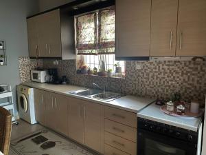 a kitchen with wooden cabinets and a sink and a dishwasher at Sady's House in Yimnón +3 photos