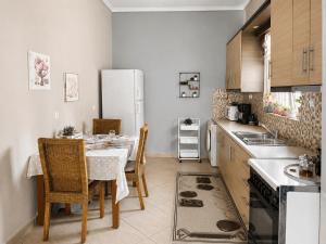 a kitchen with a table and a white refrigerator at Sady's House in Yimnón