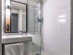 a bathroom with a sink and a shower with a mirror at ibis Metz Centre Cathedrale in Metz