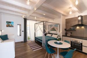 a room with a bed and a table and chairs at Centro Storico Rooms & Suites in Manfredonia