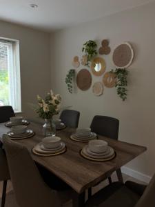 a dining room table with chairs and plates on it at Number 1 School Path in Coalbrookdale