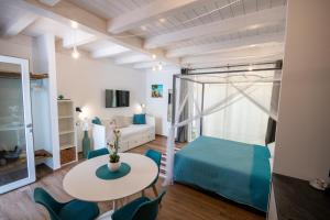 a room with a bed and a table and chairs at Centro Storico Rooms & Suites in Manfredonia