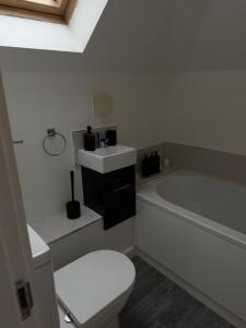 a bathroom with a toilet and a tub and a sink at Number 1 School Path in Coalbrookdale +18 photos
