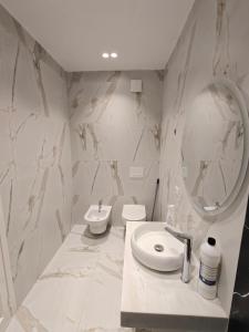 a bathroom with a sink and a toilet and a mirror at DfA in Tirana