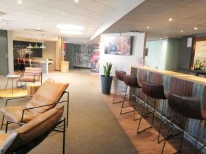 a bar in a restaurant with chairs and a counter at ibis Poitiers Sud in Poitiers
