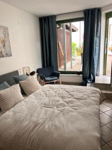 a bedroom with a bed and a chair and a window at Hygge Cabin in Rostock