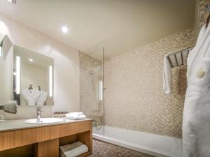 a bathroom with a sink and a shower at Pullman Bordeaux Lac in Bordeaux +170 photos