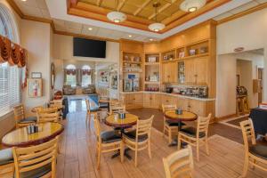 a dining room with tables and chairs and a kitchen at Best Western Fredericksburg in Fredericksburg