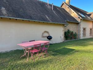 a pink table and chairs in the yard of a house at La Bernache Solognote in Viglain