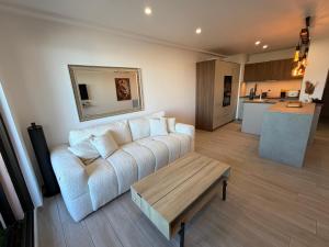 a living room with a white couch and a table at T2 "Bohême" vue mer, centre ville tout à pied in Le Lavandou