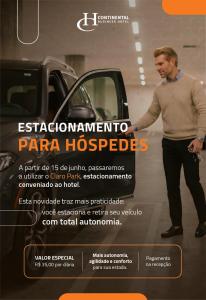a man standing next to a car in a dealership at Hotel Continental Business - 200 metros do Complexo Hospitalar Santa Casa in Porto Alegre