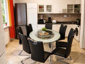 a kitchen with a glass table and black chairs at 110m2 Old Town Apartment on Danube Promenade 3BR 2BA Up to 9 Guests in Bratislava
