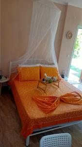 a bedroom with a bed with an orange comforter at Bright Sea - Studios in Limenas