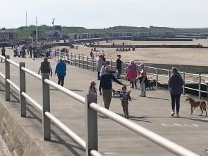 a group of people walking on the beach at Bay Lodge in Birchington