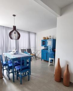 a dining room with a blue table and chairs at Apartamento Confortável na Praia do Morro in Guarapari