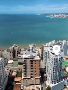 a view of a city with buildings and the ocean at Apartamento Confortável na Praia do Morro in Guarapari