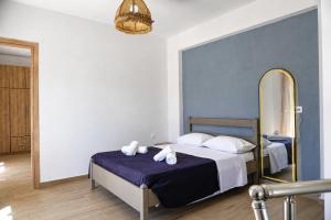 a bedroom with a bed with a large mirror at Karies House in Kefalos