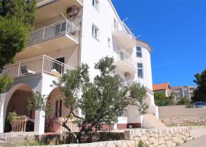 a white building with a tree in front of it at Apartment Nana in Primošten