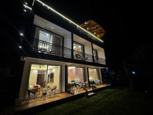 a house with a deck with chairs and tables at night at Hotel Casa Del Sol Near'Bhimtal Lake in Bhīm Tāl +25 photos