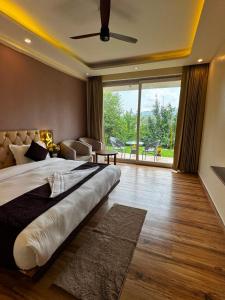 a bedroom with a large bed and a large window at Hotel Casa Del Sol Near'Bhimtal Lake in Bhīm Tāl