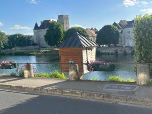a small building on the side of a river at De passage in Nemours +4 photos