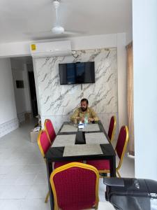 a man sitting at a table in a room at ZAN Lodge in Male City