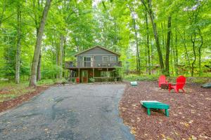 a house in the middle of a forest with red chairs at Crystal Mountain Resort Cabin: Golf, Hike, Swim! in Thompsonville