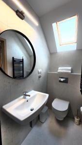 a bathroom with a sink and a mirror and a toilet at Willa Wladek in Władysławowo
