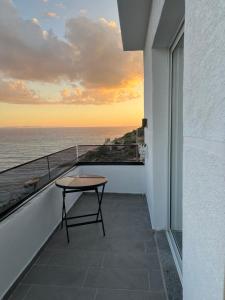 a table on a balcony with a view of the ocean at Villa Besnik in Sarandë