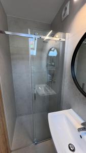 a shower with a glass door next to a sink at Willa Wladek in Władysławowo