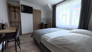 a bedroom with a bed and a desk and a window at Willa Wladek in Władysławowo