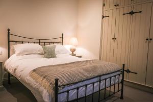 a bedroom with a large bed with white sheets and pillows at Oaters Wood in Petworth