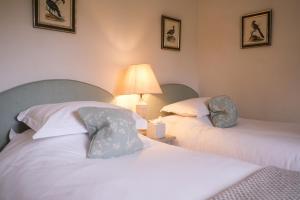 two beds sitting next to each other in a room at Oaters Wood in Petworth