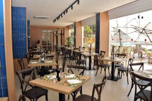 a restaurant with wooden tables and chairs and a large window at Hotel Salobreña Suites in Salobreña