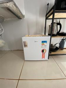 a white refrigerator sitting on the floor in a kitchen at Flat aconchegante é silencioso in Rio Verde +12 photos