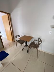 a table and two chairs in a room at Flat aconchegante é silencioso in Rio Verde
