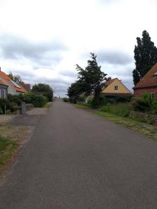 an empty road in a residential neighborhood with houses at Charming Villa close to the sea in Errindlev