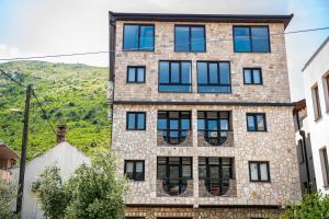 a brick building with black windows on a hill at Villa Anri in Mostar