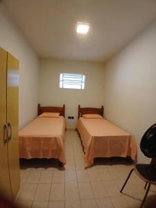 two beds in a room with a window at Jardim Teresa - Até 10 pessoas, próximo ao Açude Velho, Centro Histórico e Parque do Povo in Campina Grande