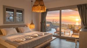 a bedroom with a bed and a balcony with a sunset at Erimo Vip in Vourvoúlos