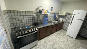 a kitchen with a stove and a refrigerator at Jardim Teresa - Até 10 pessoas, próximo ao Açude Velho, Centro Histórico e Parque do Povo in Campina Grande