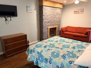 a bedroom with a bed and a red couch at Lake Access Retreat Pet Friendly Fire Pit in Geneva