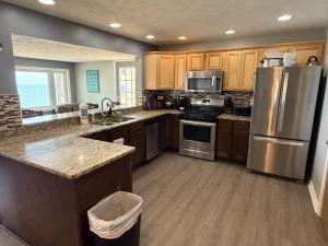 a kitchen with stainless steel appliances and wooden cabinets at Lake Access Retreat Pet Friendly Fire Pit in Geneva