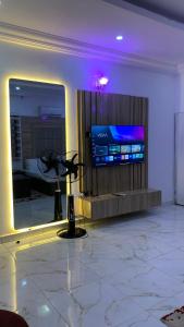 a room with a flat screen tv in a building at Halijomak Apartments in Abuja