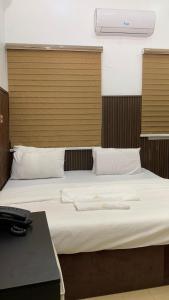 a bedroom with a large bed with a wooden headboard at Halijomak Apartments in Abuja