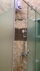 a shower in a bathroom with a glass door at Halijomak Apartments in Abuja +22 photos