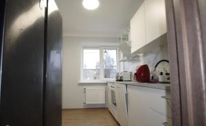 a kitchen with white cabinets and a black refrigerator at ST Luxury Apartment Riga in Riga