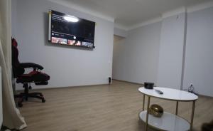 a room with a chair and a monitor on a wall at ST Luxury Apartment Riga in Riga
