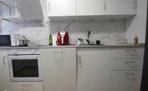 a kitchen with white cabinets and a red appliance at ST Luxury Apartment Riga in Riga